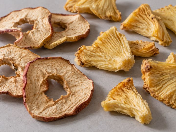 Rodajas de manzana y trozos de piña deshidratados.